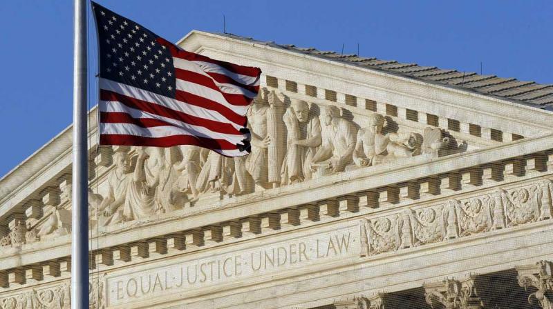 US Supreme Court building facade with American flag waving.